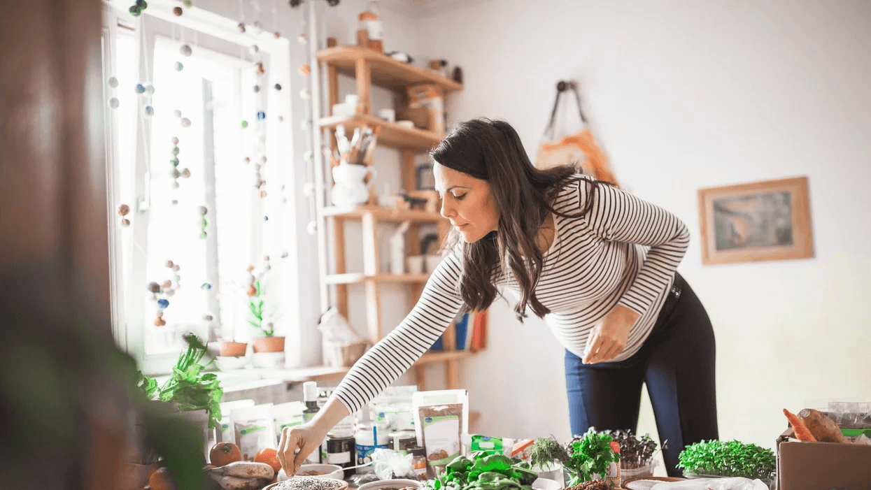 pregnant woman tending to organic herb garden