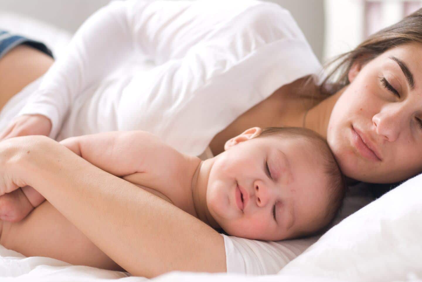 mom and baby co-sleeping together in bed