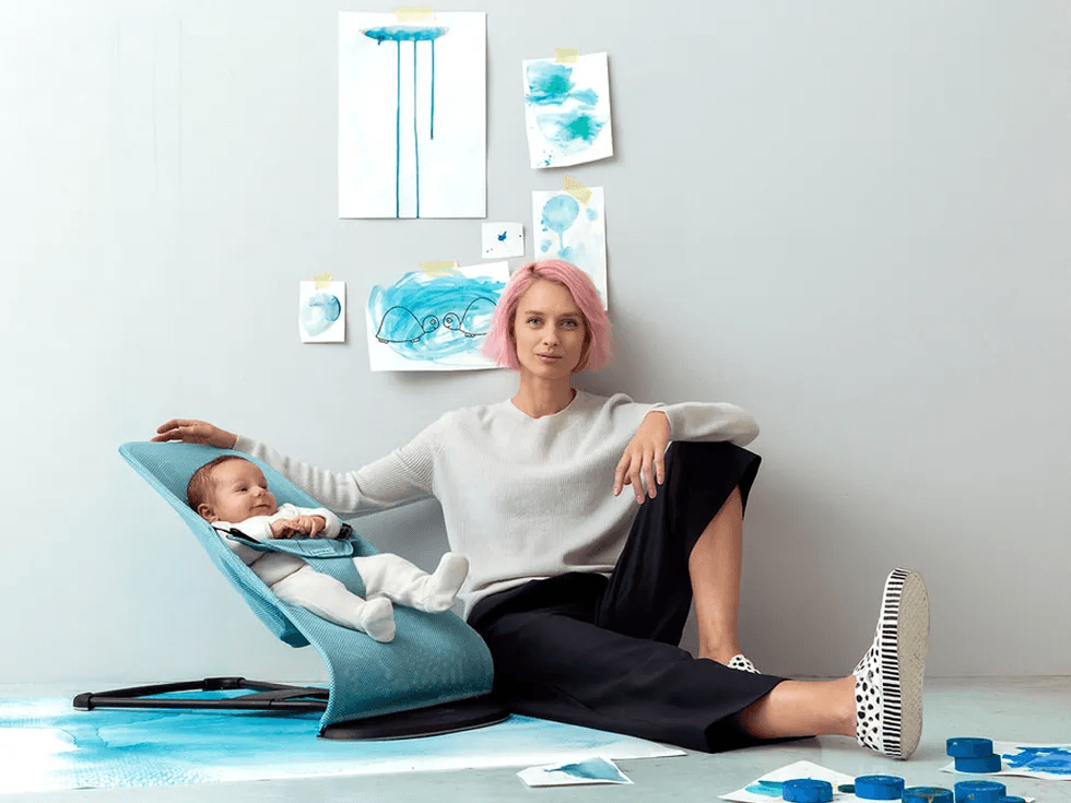 woman sitting next o a baby in a Babybjörn rocker