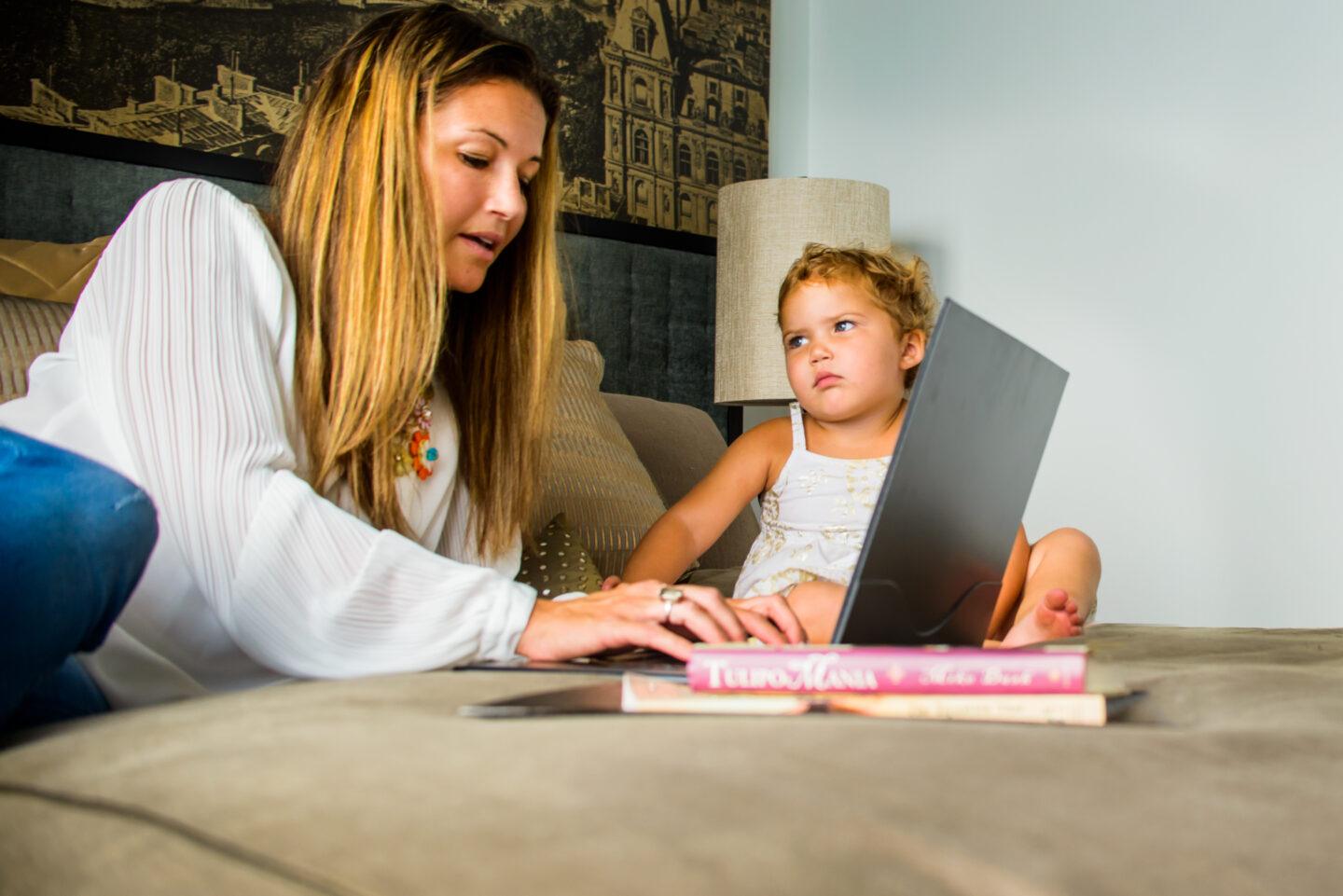 working mom on computer with toddler