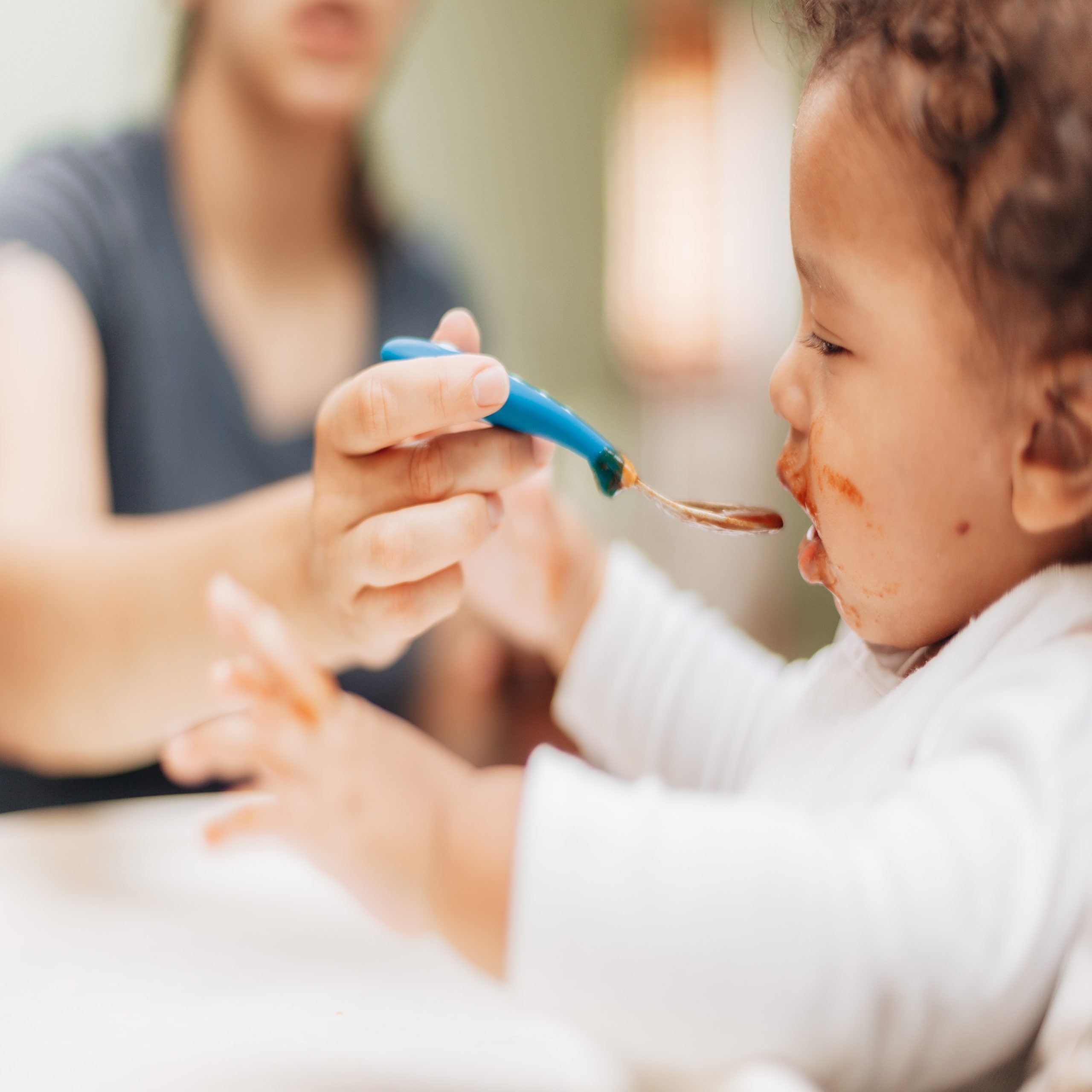 mom feeding baby with a spoon