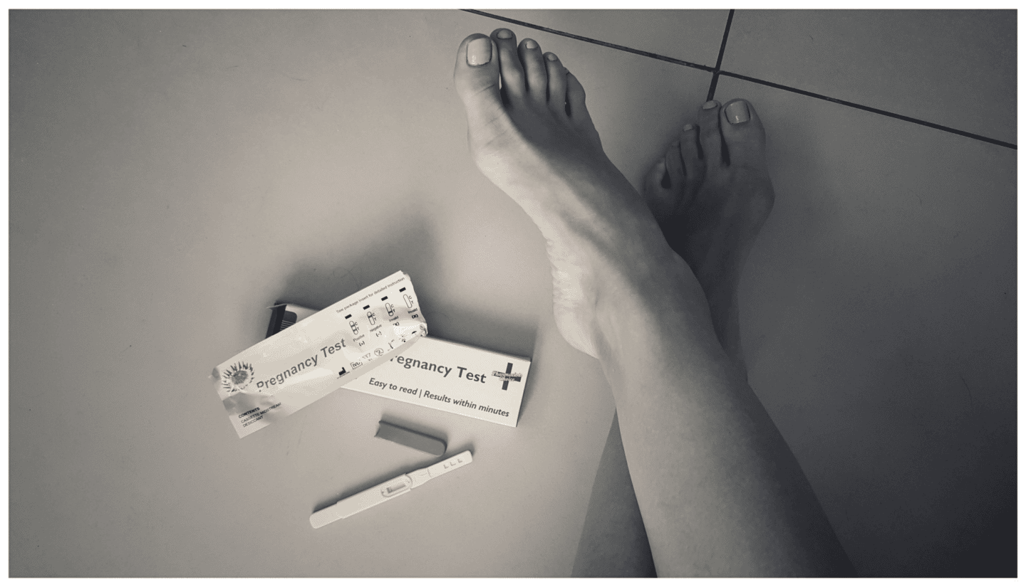 womans feet next to pregnancy tests