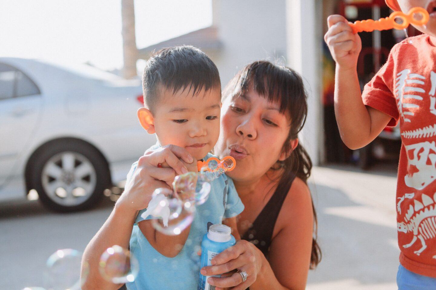 SAHM mom with two sons blowing bubbles