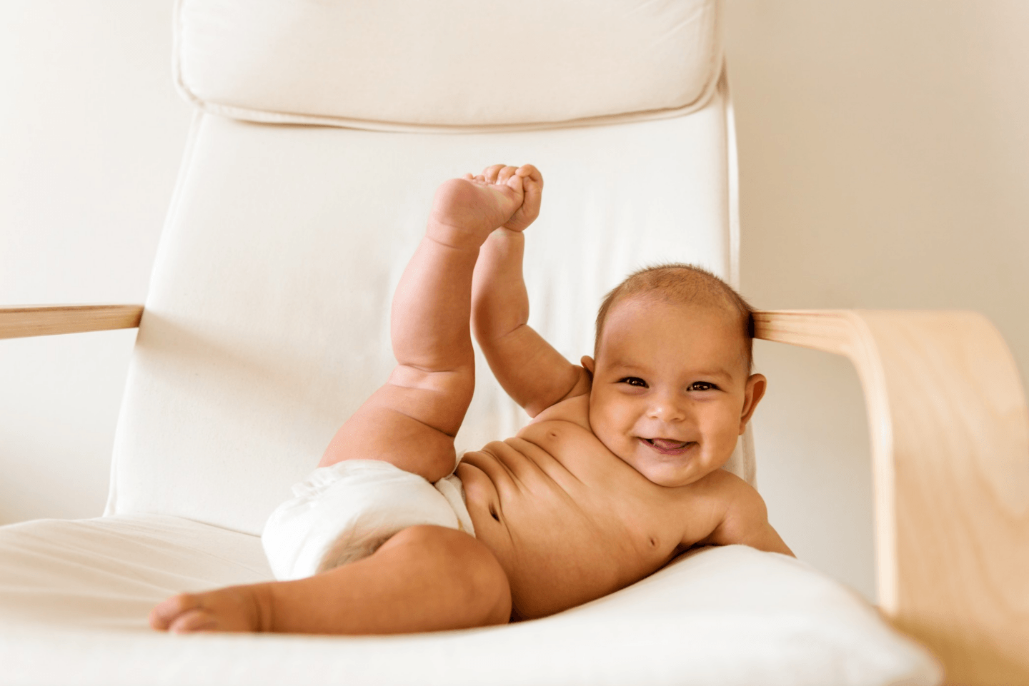 baby grabbing toes on a chair