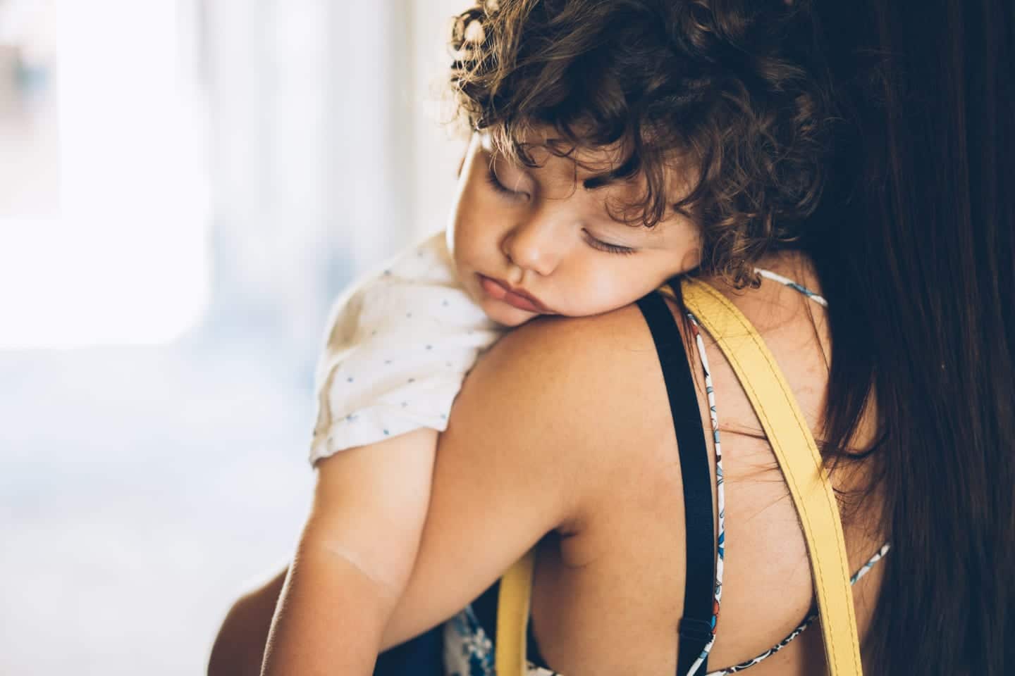 mom holding a sleeping toddler - two naps to one