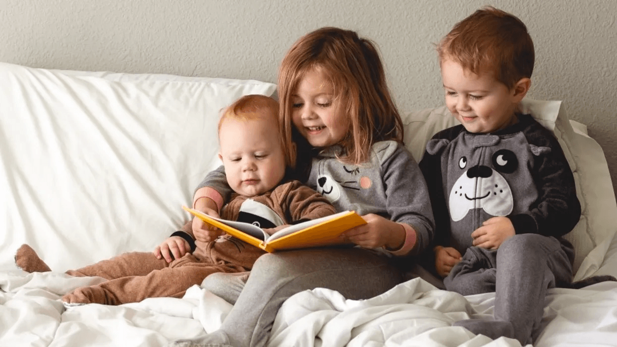 three kids reading on bed- winter holiday books