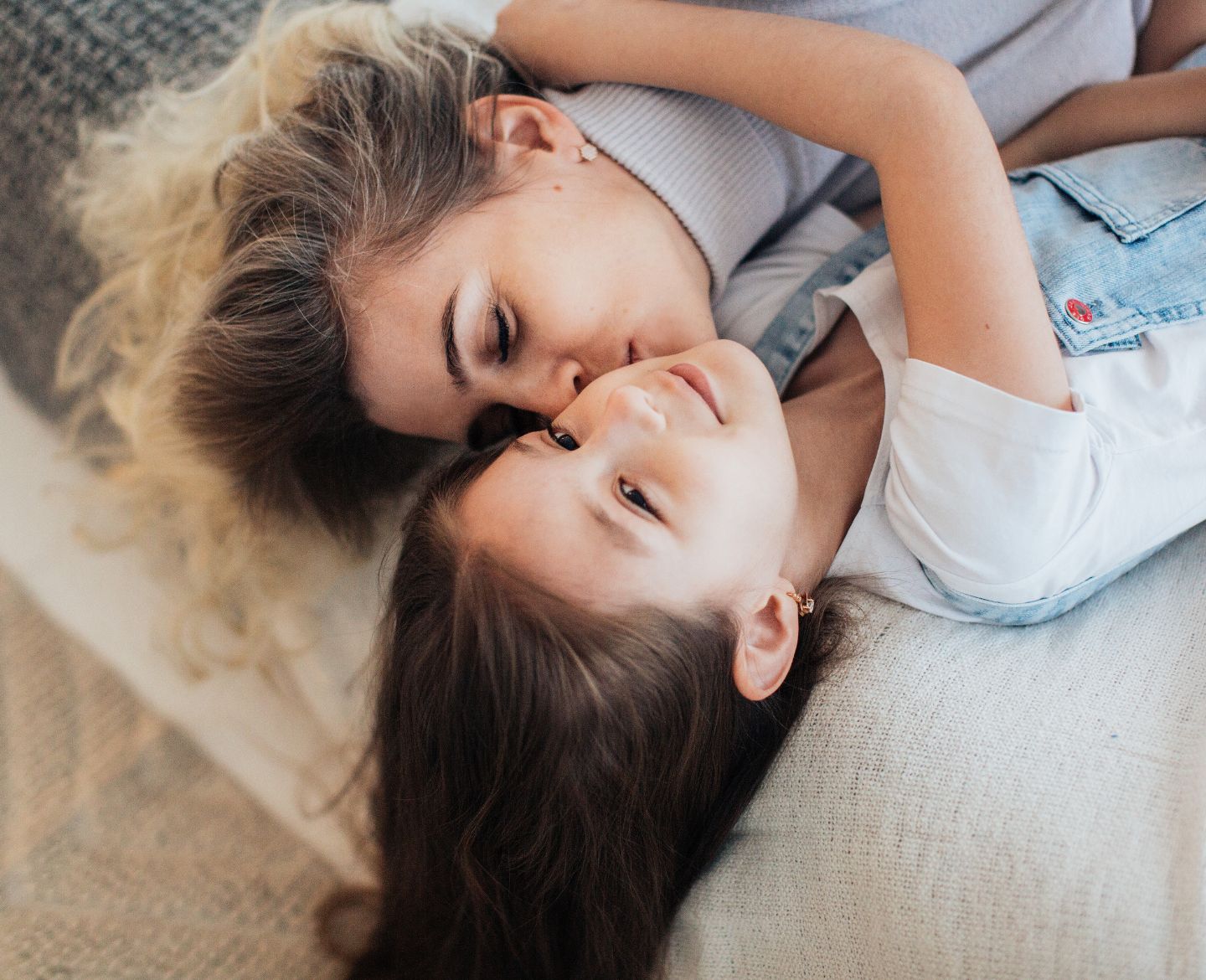 mom and daughter snuggling on bed