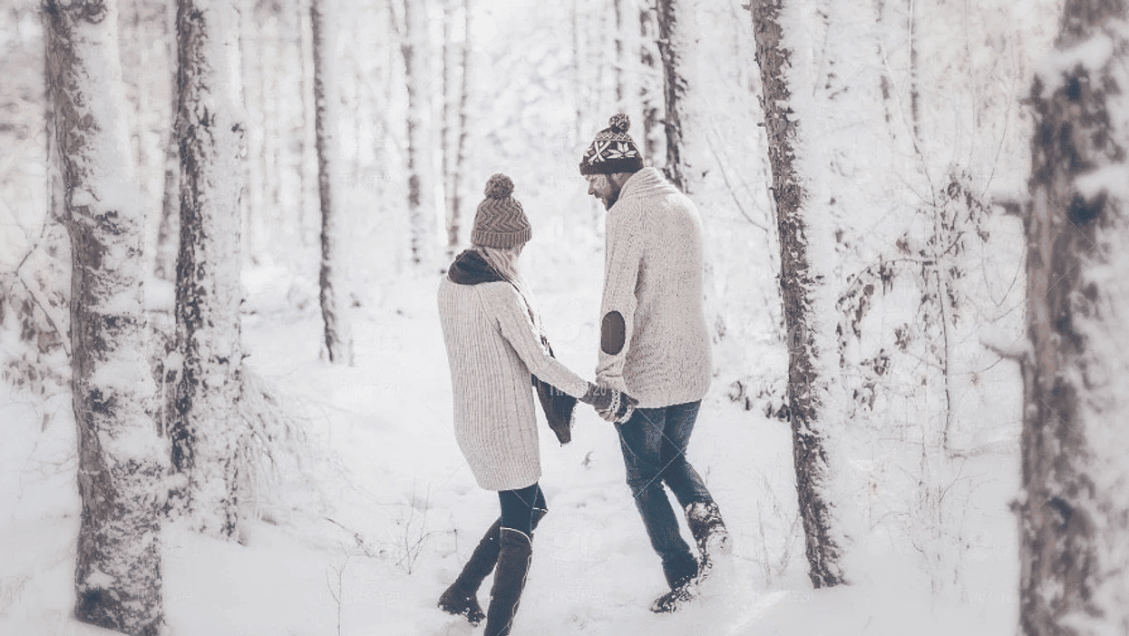 couple walking through the snow holding hands
