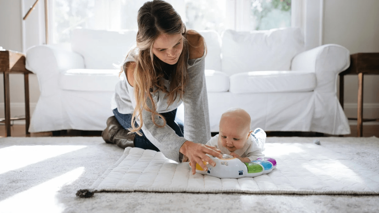woman playing with 4-month-old doing tummy time