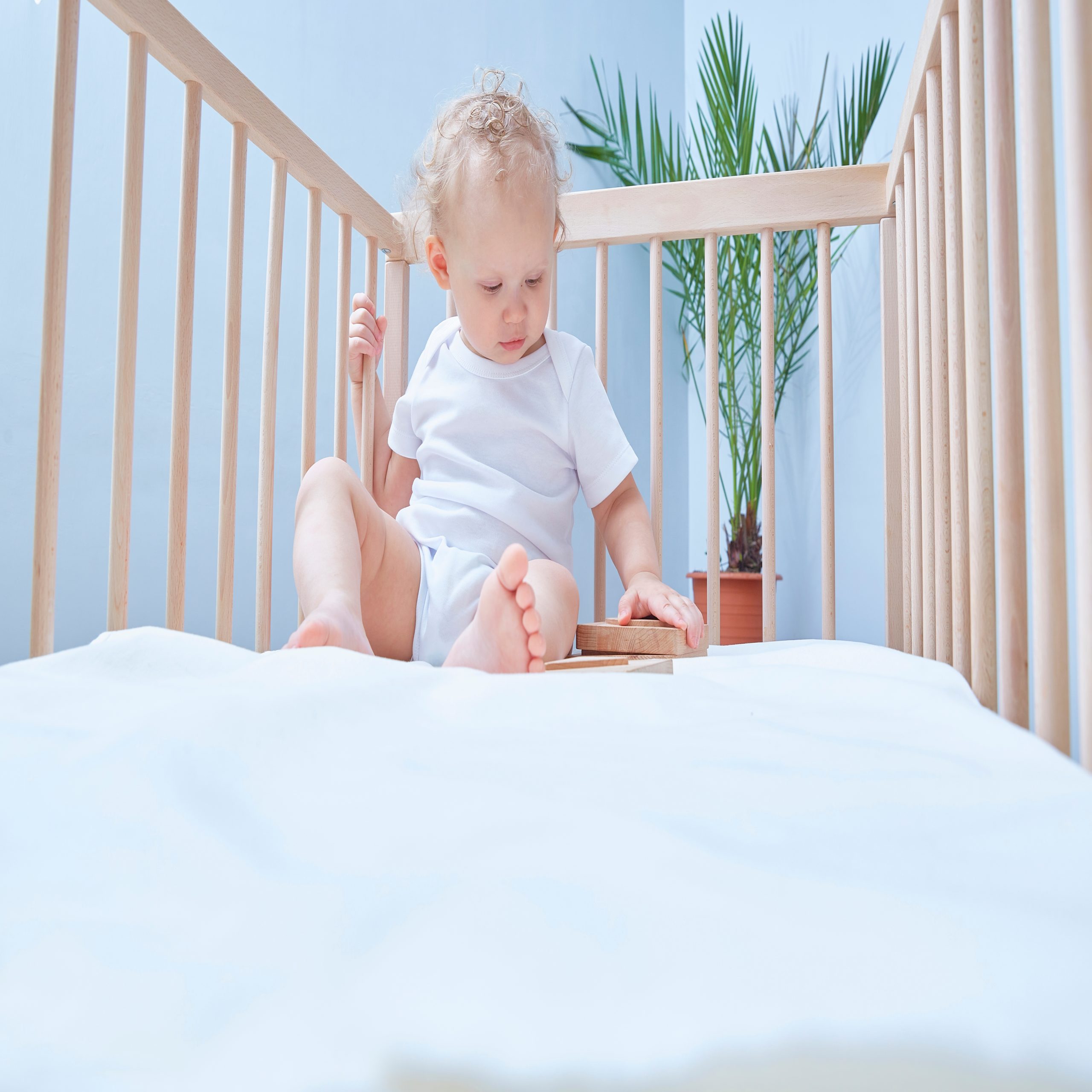 baby playing in minimalist crib