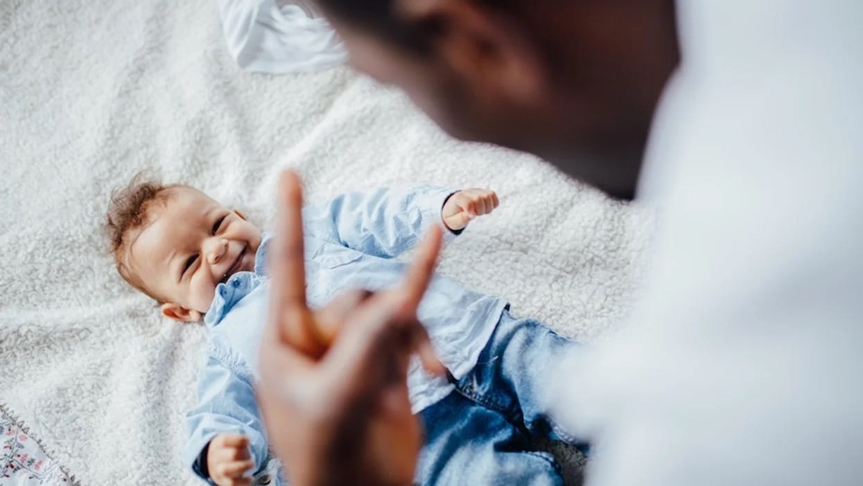 dad giving baby i love you sign