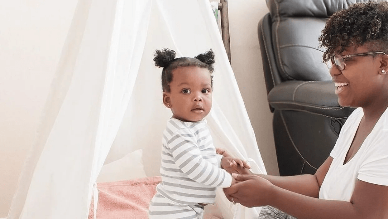 mom holding toddlers hands