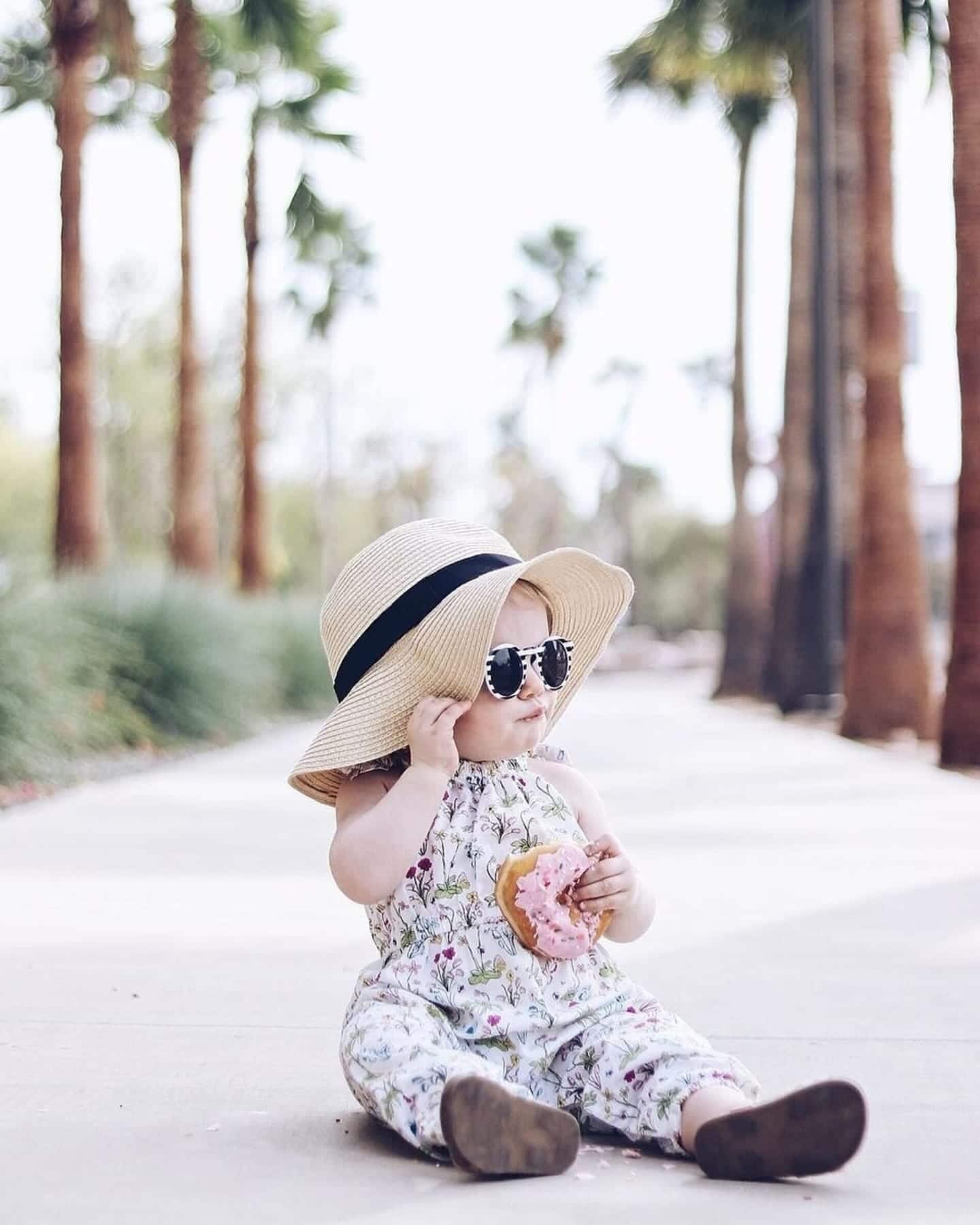 baby wearing a hat and eating a donut