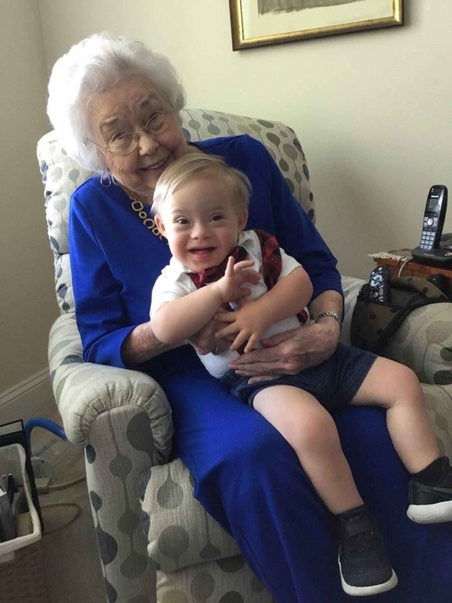 a baby sitting on his grandmother's lap