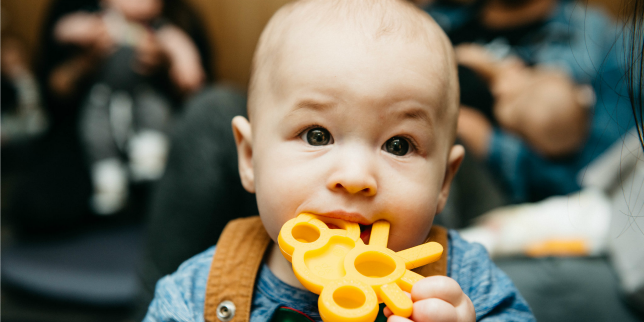 baby chewing on teething toy