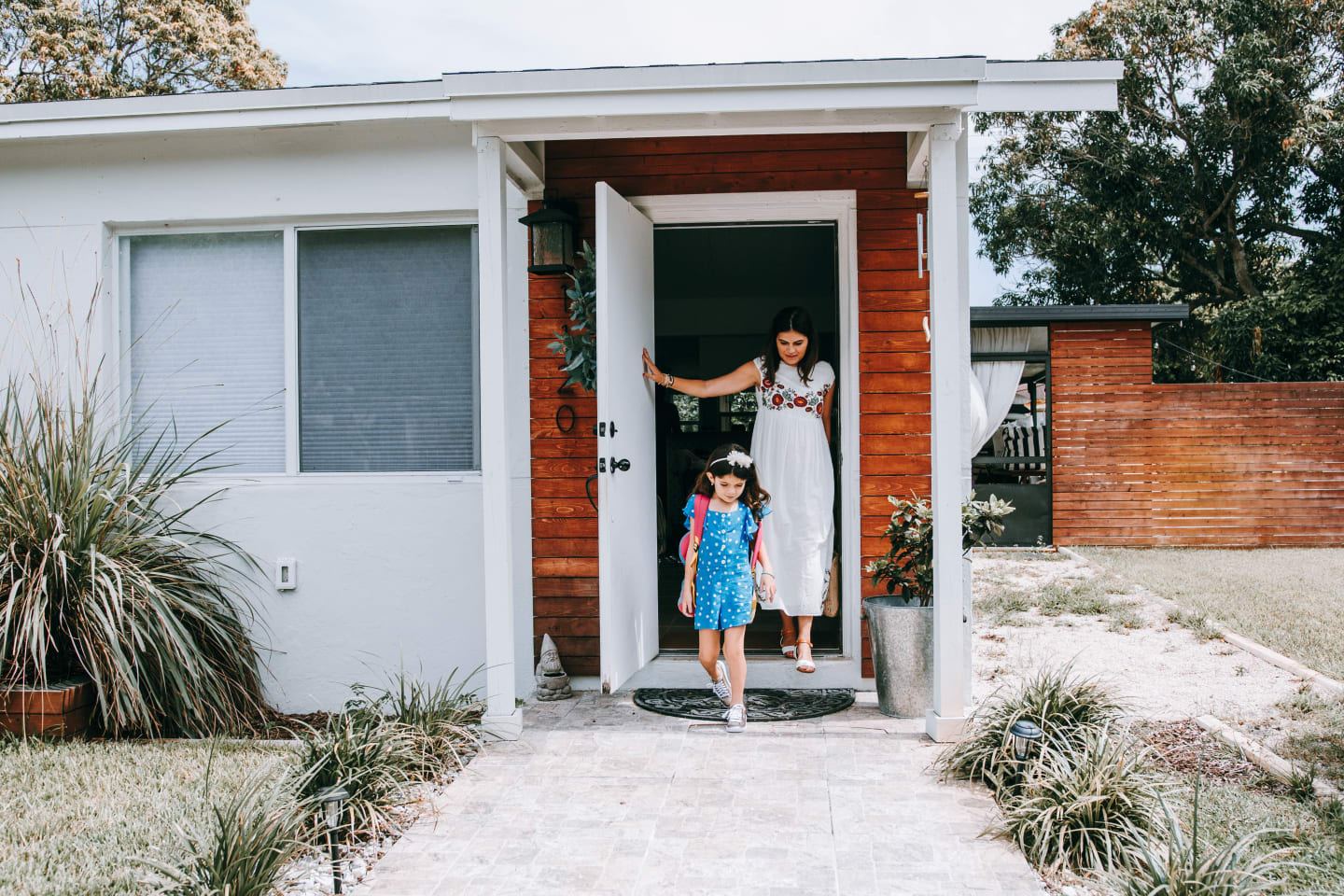 mom and child in front of a house