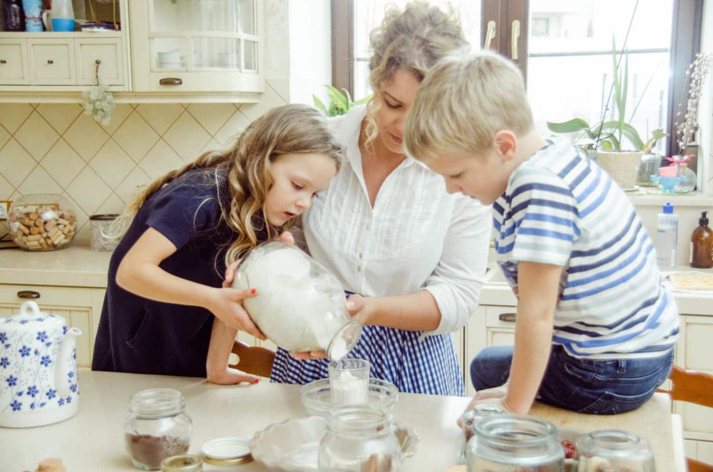 Mom pouring milk with 2 children