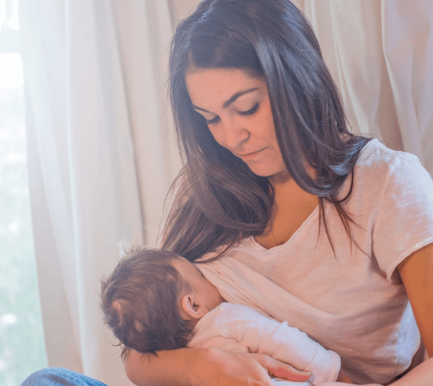 woman breastfeeding baby under her shirt
