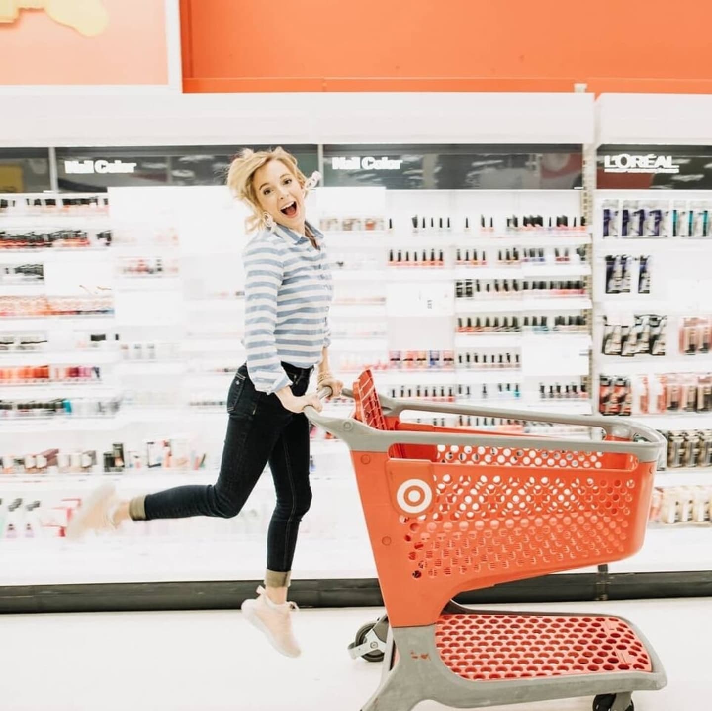 woman jumping while pushing a target cart