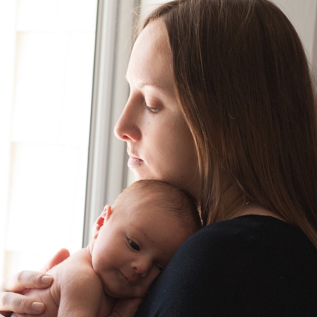 mom holding baby against her shoulder - postpartum depression essay