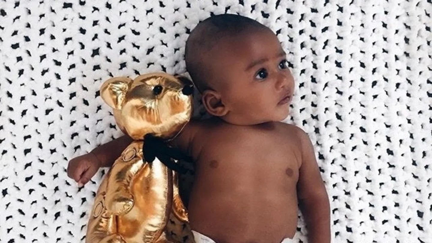 baby laying down with a gold stuffed bear - 4 month sleep regression stories