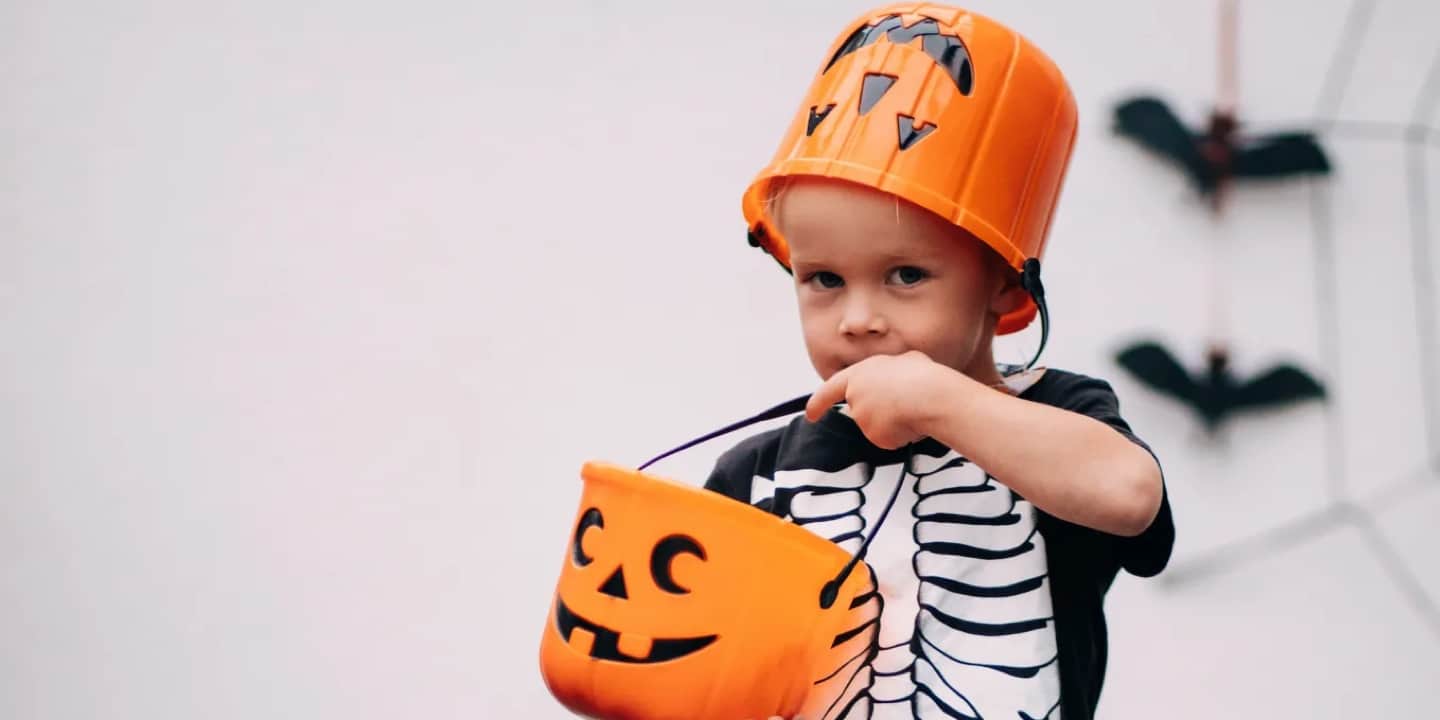 A boy dressed as a skeleton doing fun Halloween activities