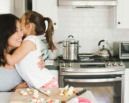 mother and daughter hugging in the kitchen Motherly