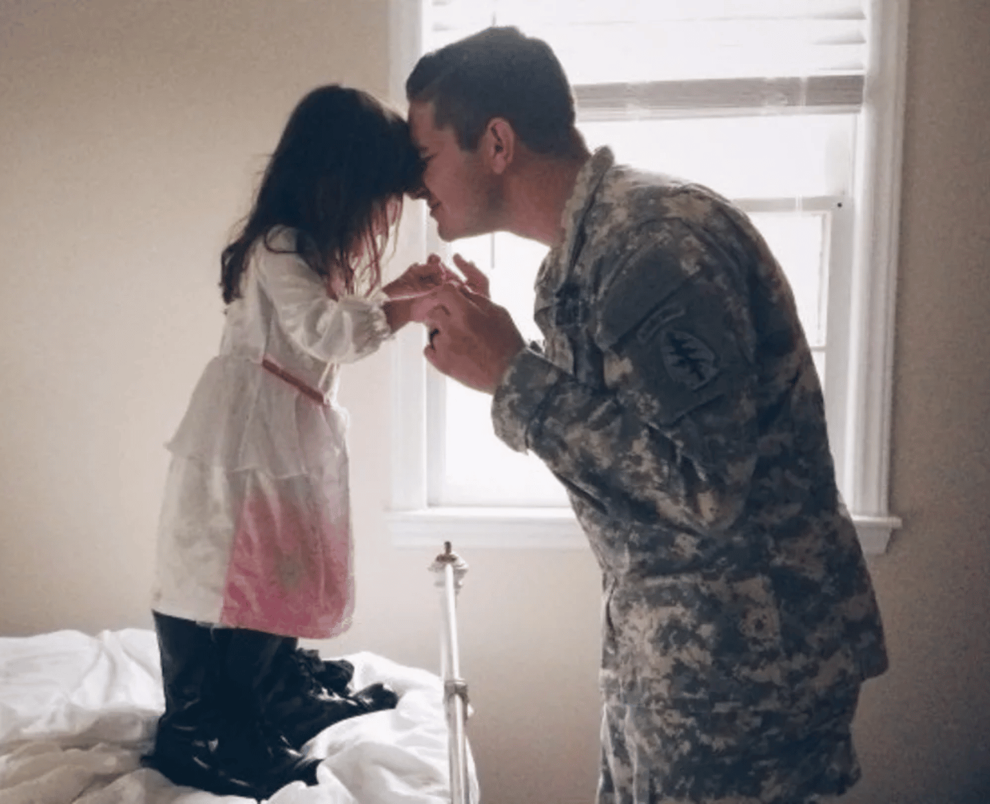 military dad kissing daughter