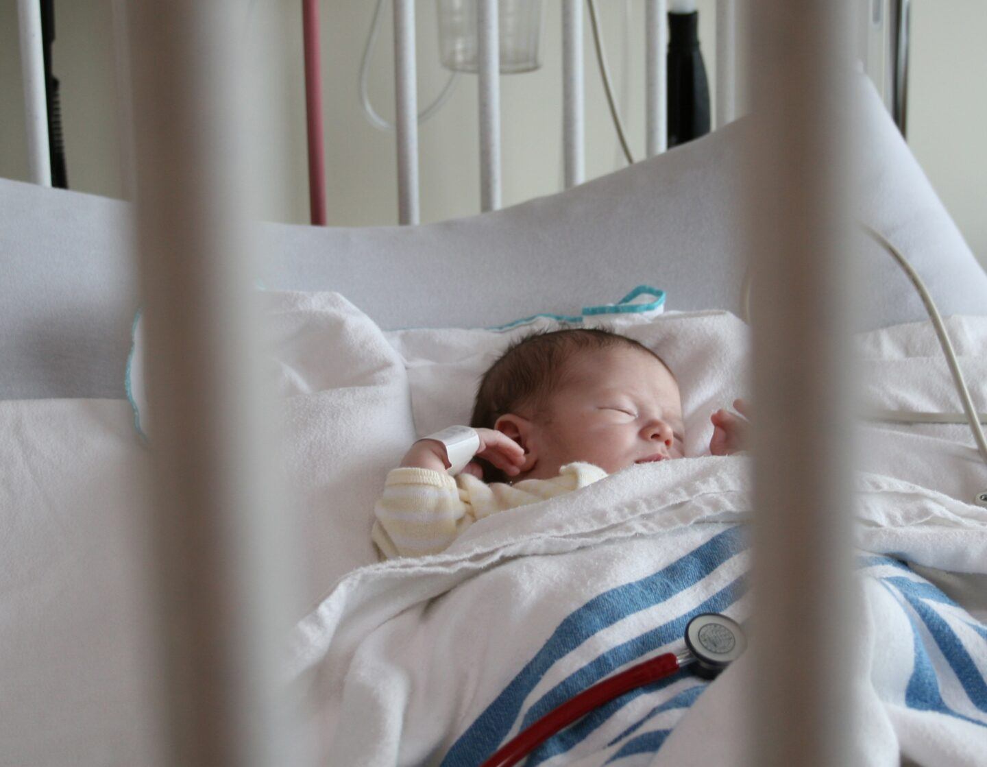 baby laying in a hospital bed