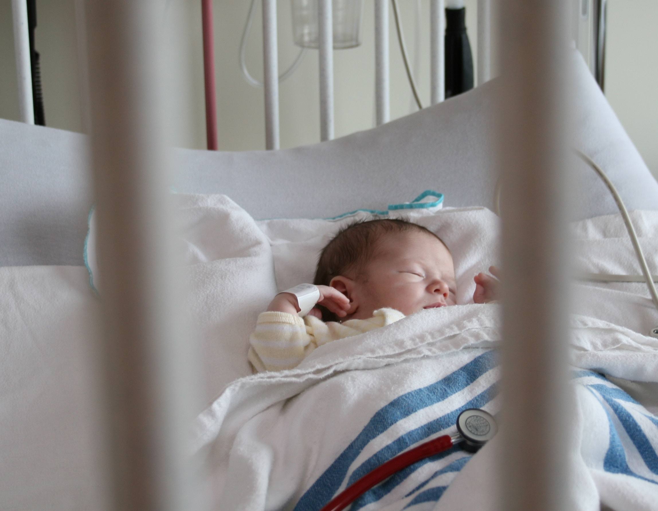 baby laying in a hospital bed