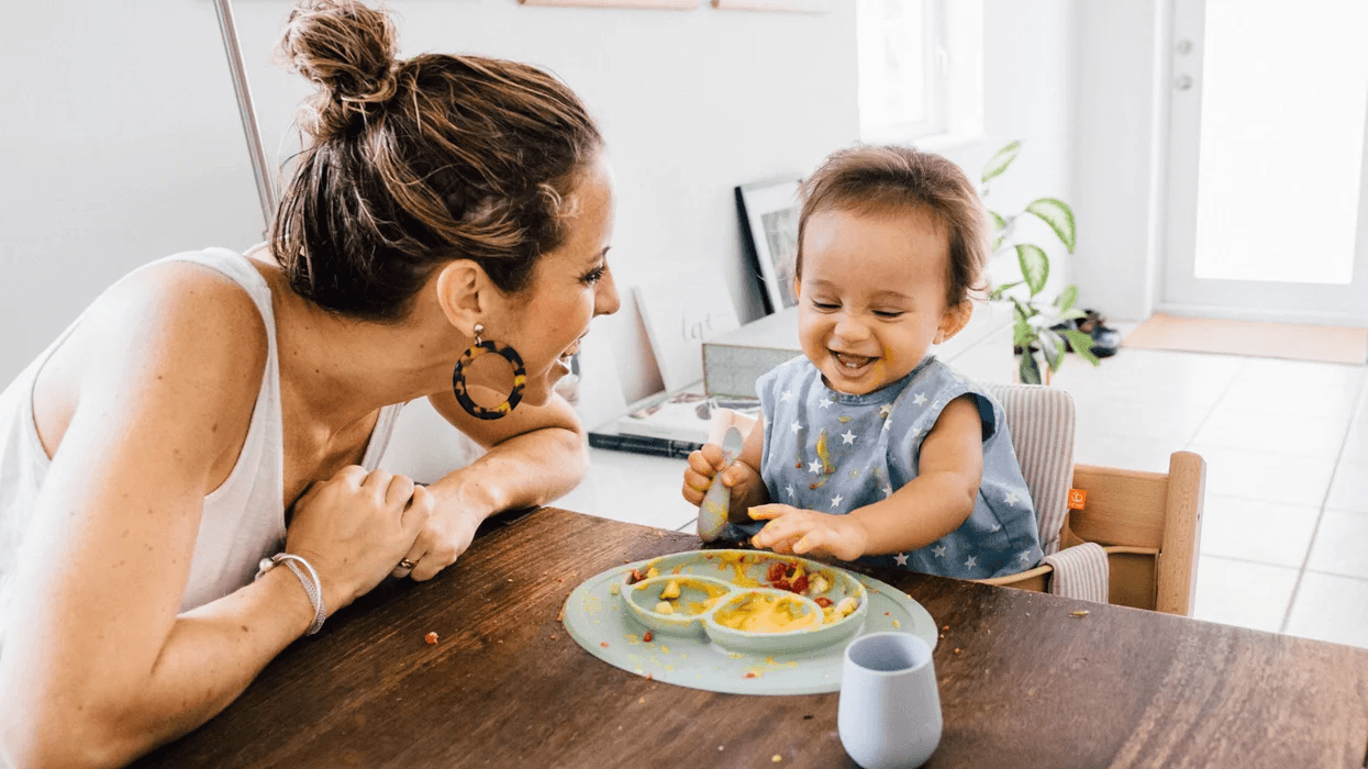 mom sitting with a baby at the table, eating