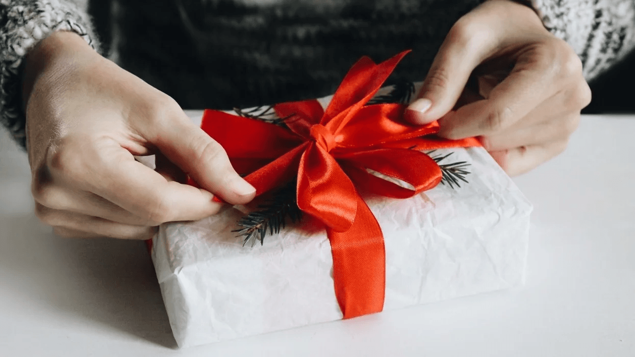 man wrapping bow around present