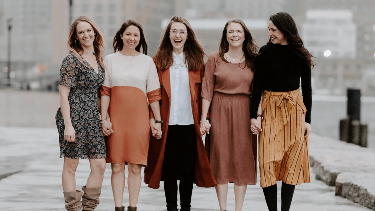 group of women standing in a line and smiling at the camera