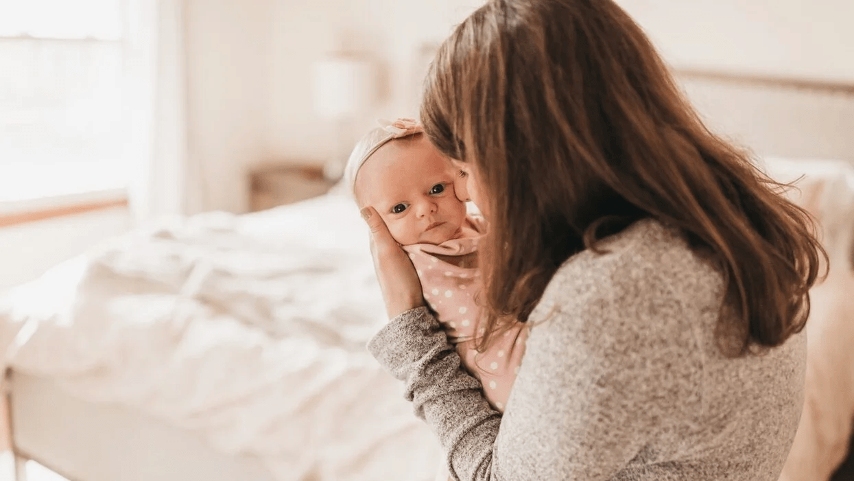 mom snuggling newborn baby