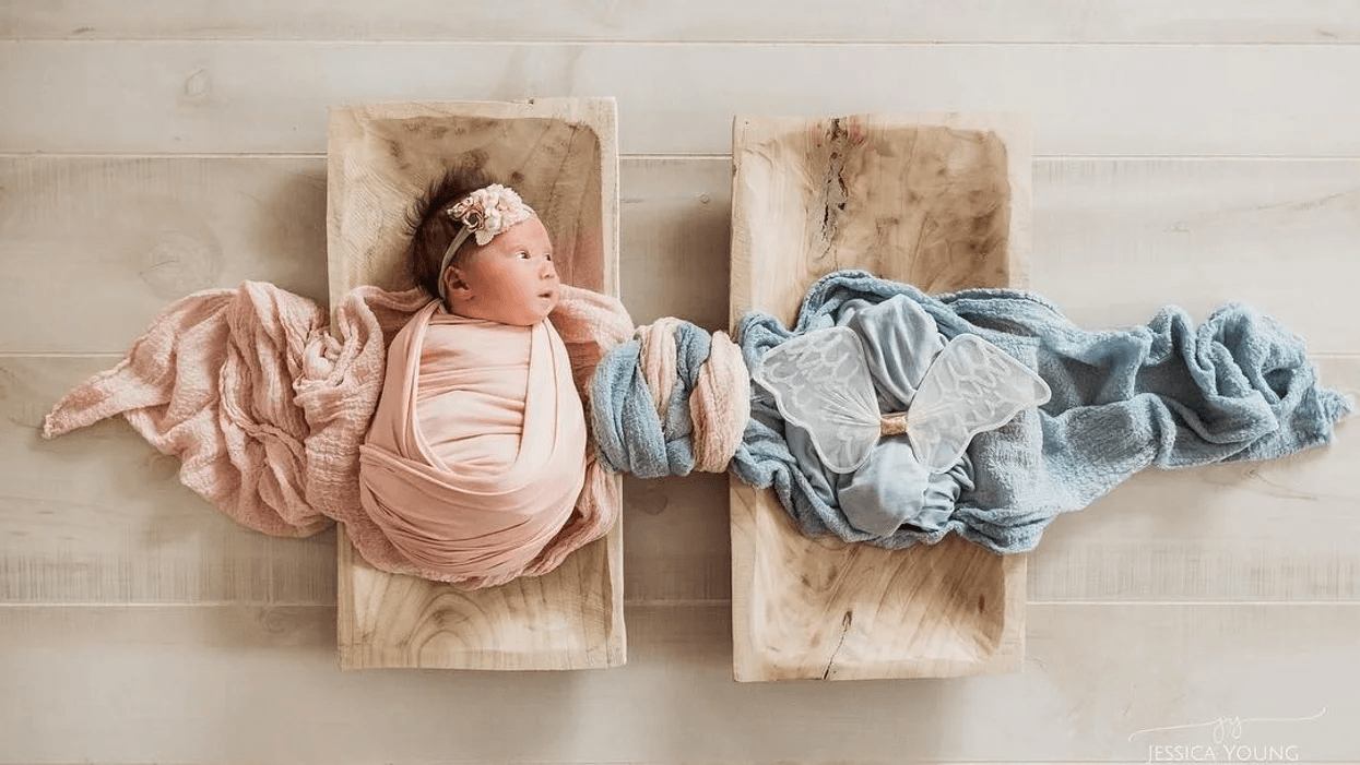 swaddled baby laying next to empty cloth