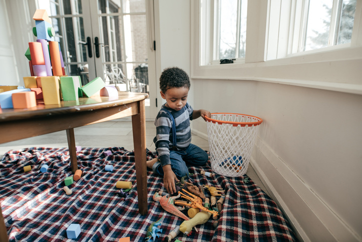 child picking up toys - how to get kids to clean up