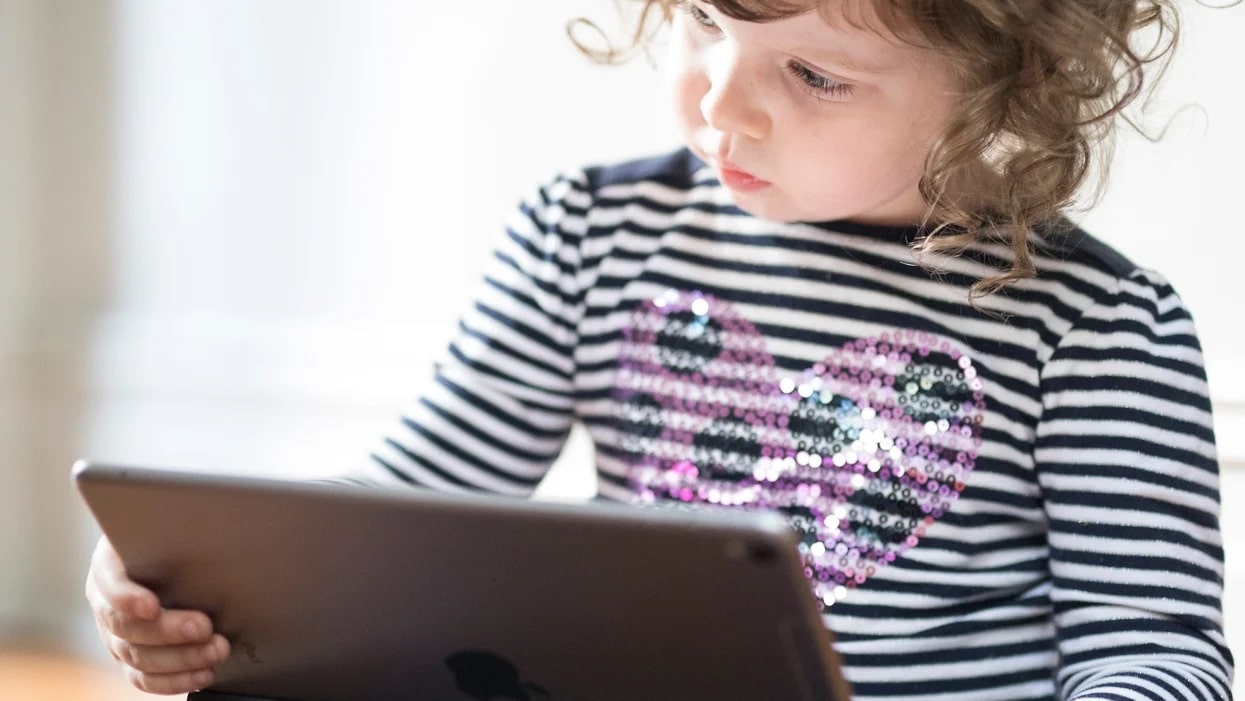 little girl playing on an ipad