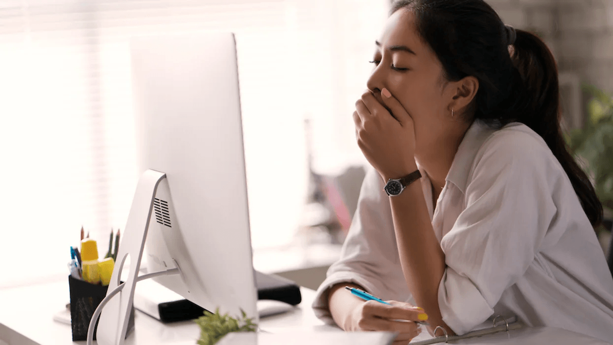 woman yawning at computer screen