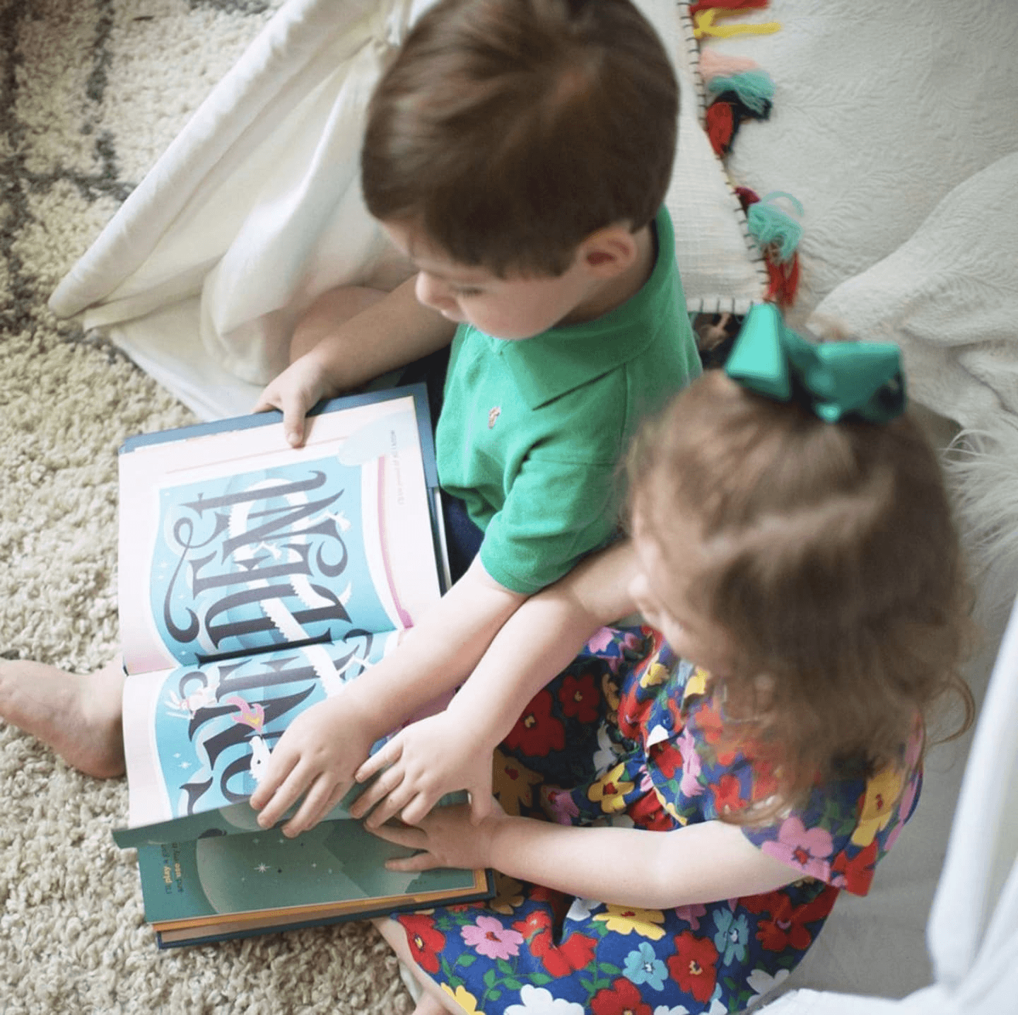 siblings reading a book together