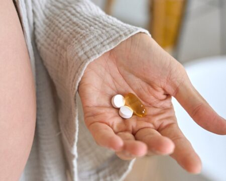 pregnant woman with pills and vitamins Motherly