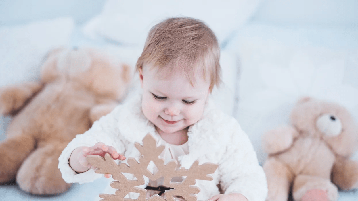 baby playing with snowflake - why no winter coats in car seat