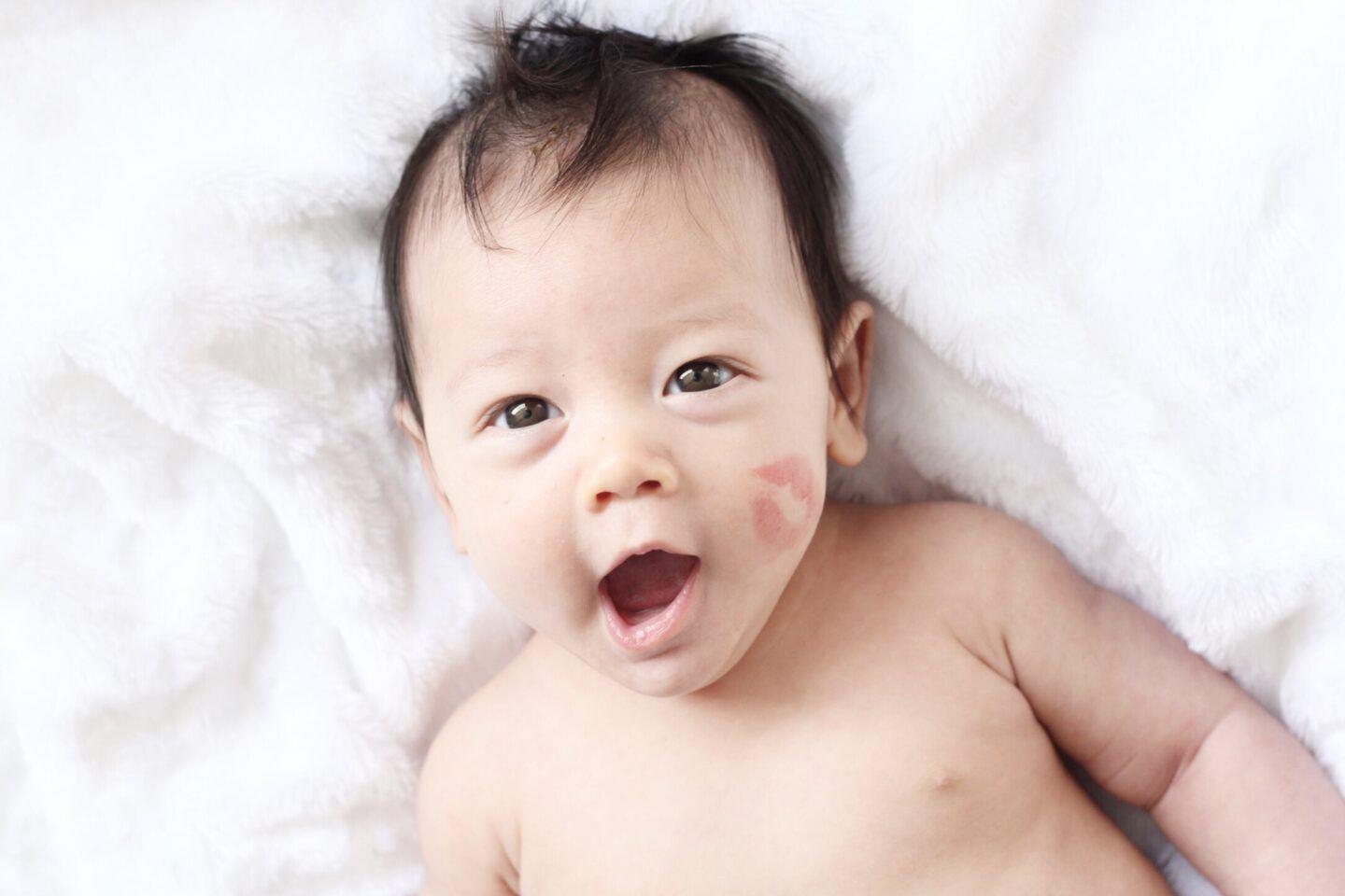 February baby with lipstick on cheek