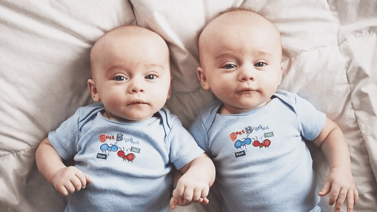 twins laying on a bed