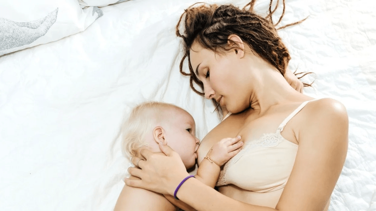 mother breastfeeding baby in bed