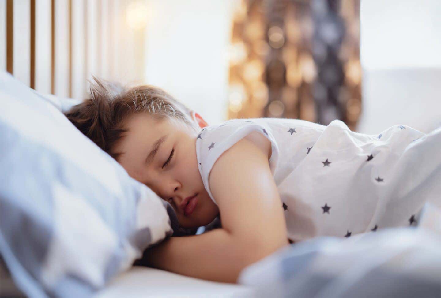 child sleeping in bed in daylight- daylight savings 2023