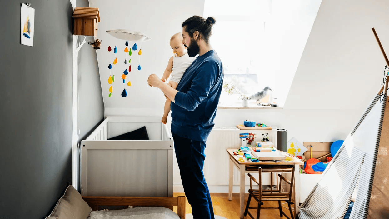 dad holding a baby in a nursery