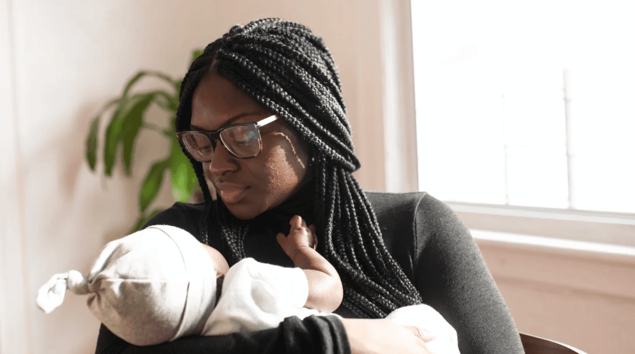 mom holding baby wearing a hat