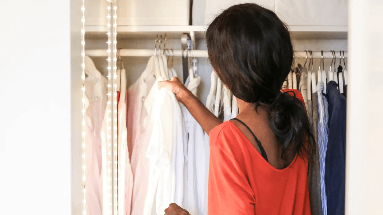 woman hanging clothes in closet