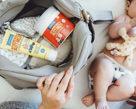 mom opening diaper bag to diaper cream