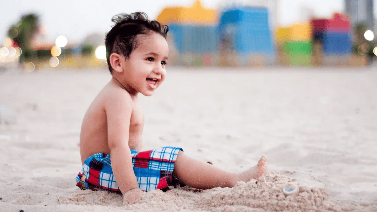 little boy sitting on the beach